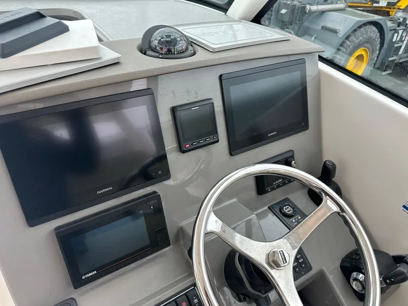 Slide: The Image of Helm of 2019 Pursuit DC 325 boat with navigation screens and steering wheel. - 4