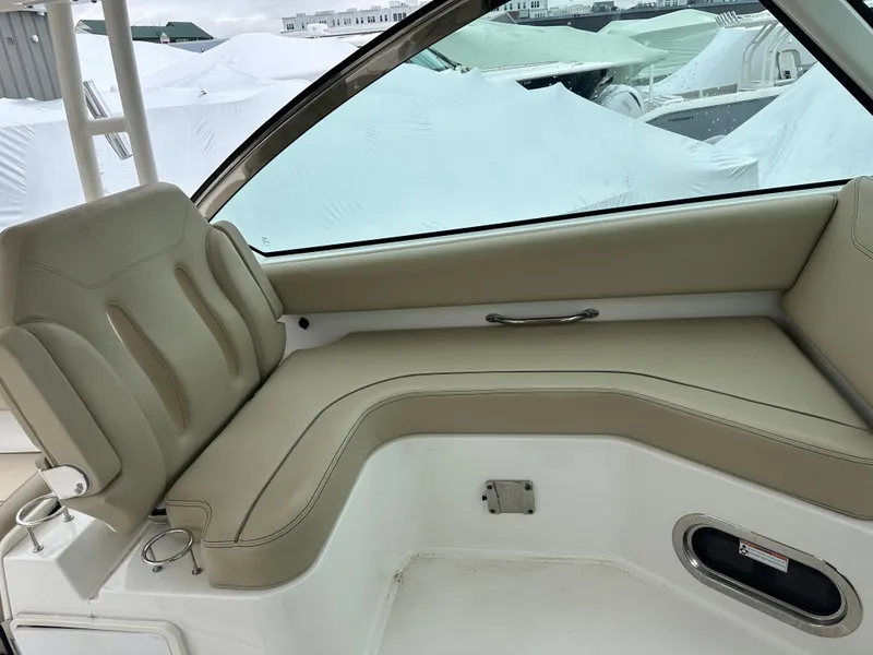 Slide: The Image of 2019 Pursuit DC 325 boat interior with beige seating and cup holders. - 6