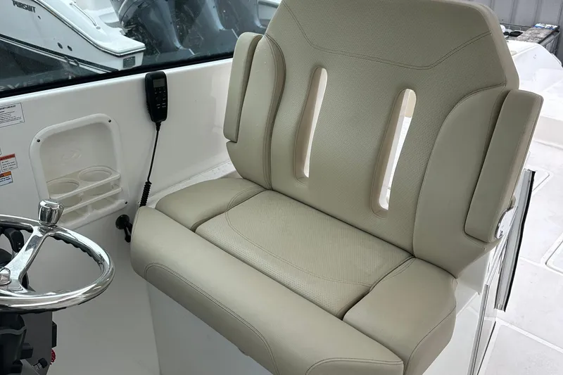 Slide: The Image of 2019 Pursuit DC 325 boat helm seat with steering wheel and controls. - 7