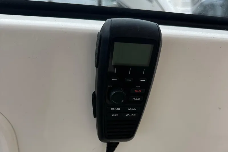 Slide: The Image of Handheld radio on 2019 Pursuit DC 325 boat dashboard. - 9
