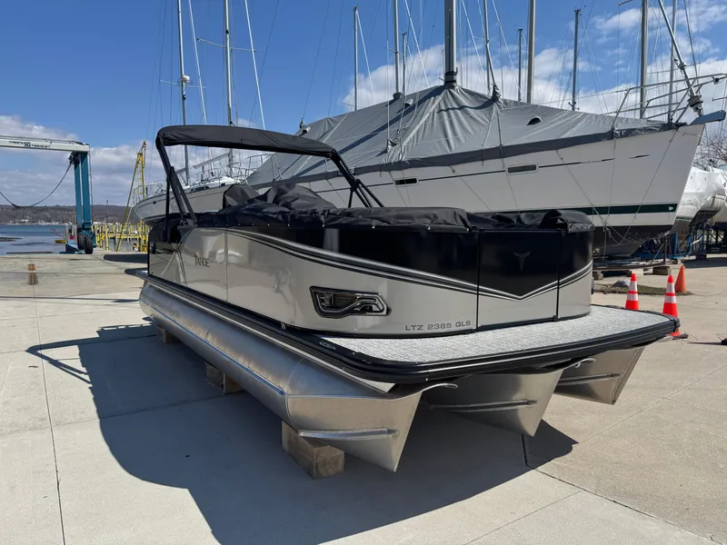 Slide: The Image of 2025 Tahoe Pontoon LTZ Quad Lounger Shift docked at marina under clear sky. - 2