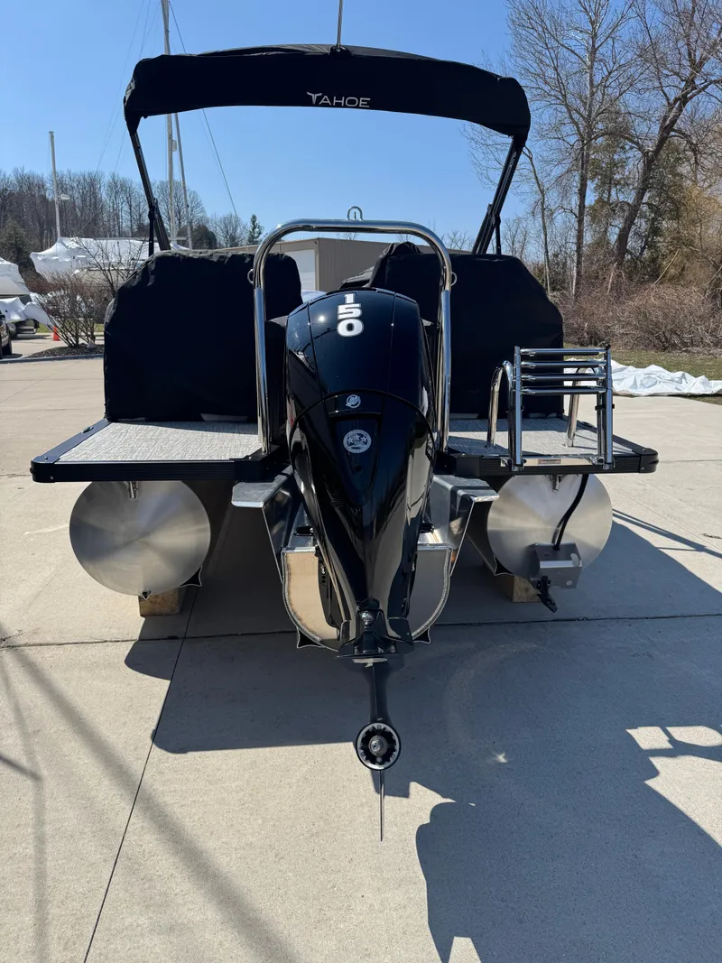 Slide: The Image of 2025 Tahoe Pontoon LTZ Quad Lounger Shift with outboard motor, docked on a sunny day. - 5