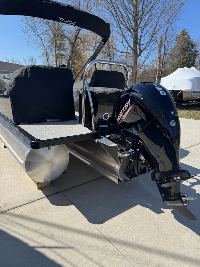 Slide: The Image of 2025 Tahoe Pontoon LTZ Quad Lounger Shift with Mercury outboard engine, parked outdoors. - 6
