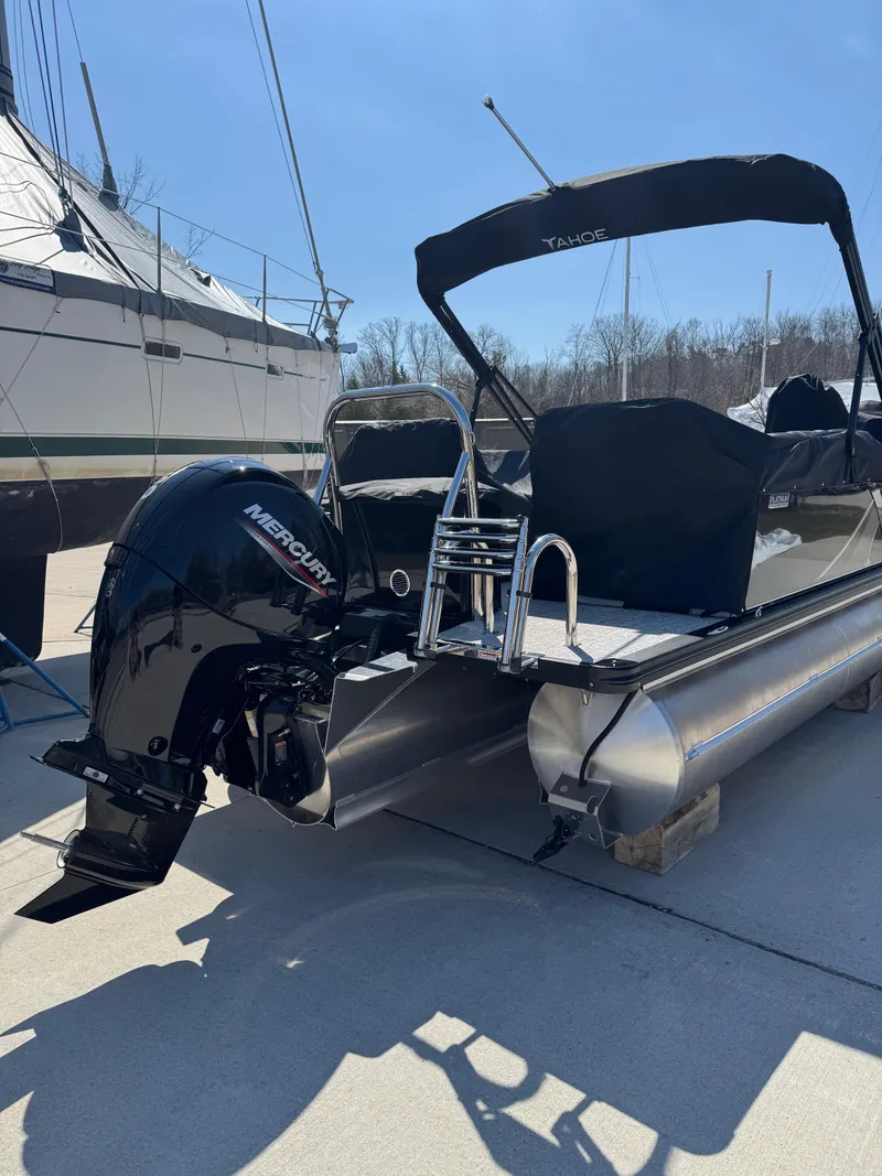 Slide: The Image of 2025 Tahoe Pontoon LTZ Quad Lounger Shift with Mercury outboard engine, docked outdoors. - 7