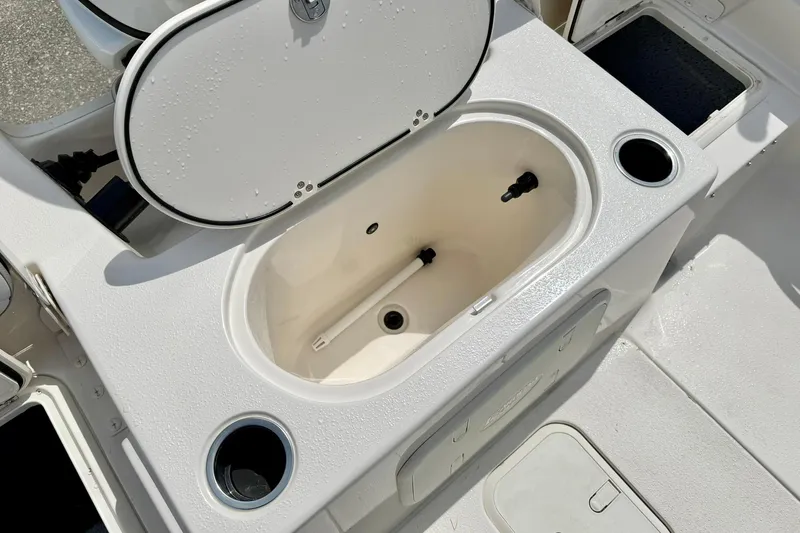 Slide: The Image of 2025 Carolina Skiff 21 LS boat with open storage compartment and cup holders. - 32