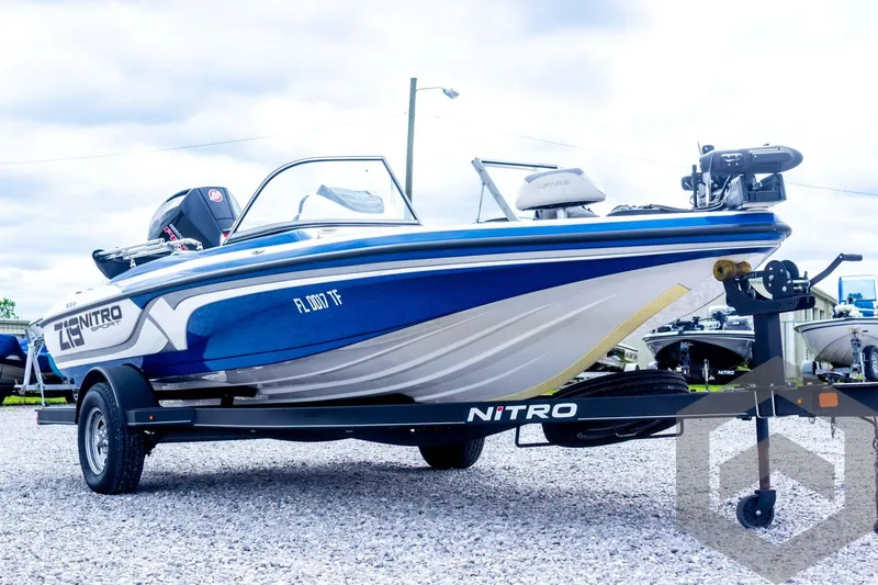 Slide: The Image of 2022 Nitro Z19 Sport boat on trailer, blue and white design, parked on gravel. - 11