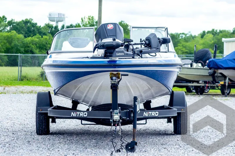 Slide: The Image of 2022 Nitro Z19 Sport boat on trailer, front view, parked outdoors. - 2