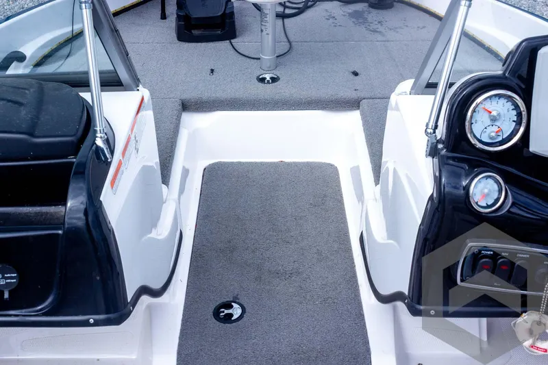Slide: The Image of 2022 Nitro Z19 Sport boat interior with gray carpet and dashboard gauges. - 28