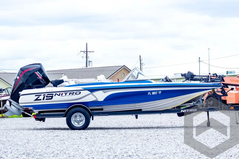 Slide: The Image of 2022 Nitro Z19 Sport boat on trailer, blue and white design, parked outdoors. - 4
