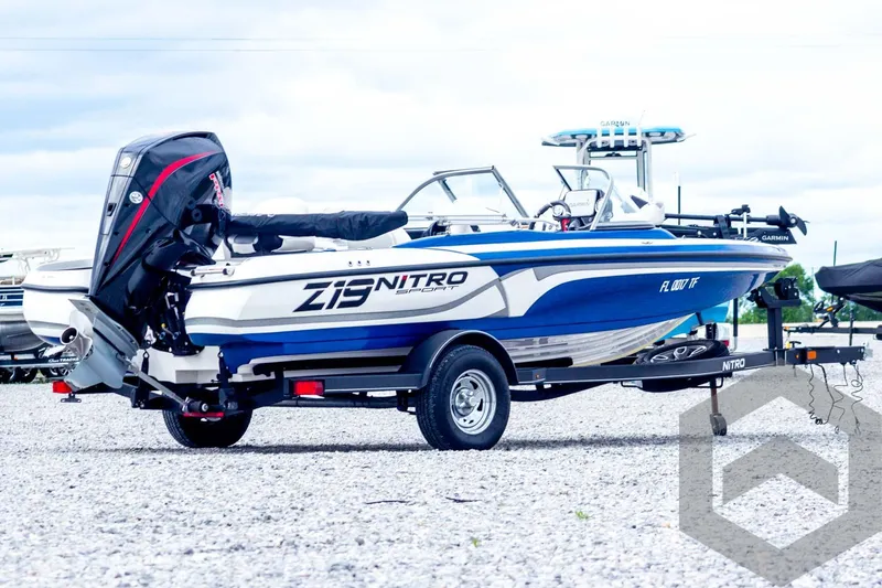 Slide: The Image of 2022 Nitro Z19 Sport boat on trailer, blue and white design, parked outdoors. - 5