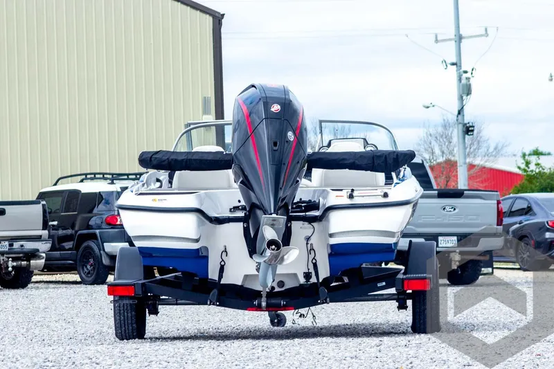 Slide: The Image of 2022 Nitro Z19 Sport boat on trailer, parked outdoors near trucks. - 6
