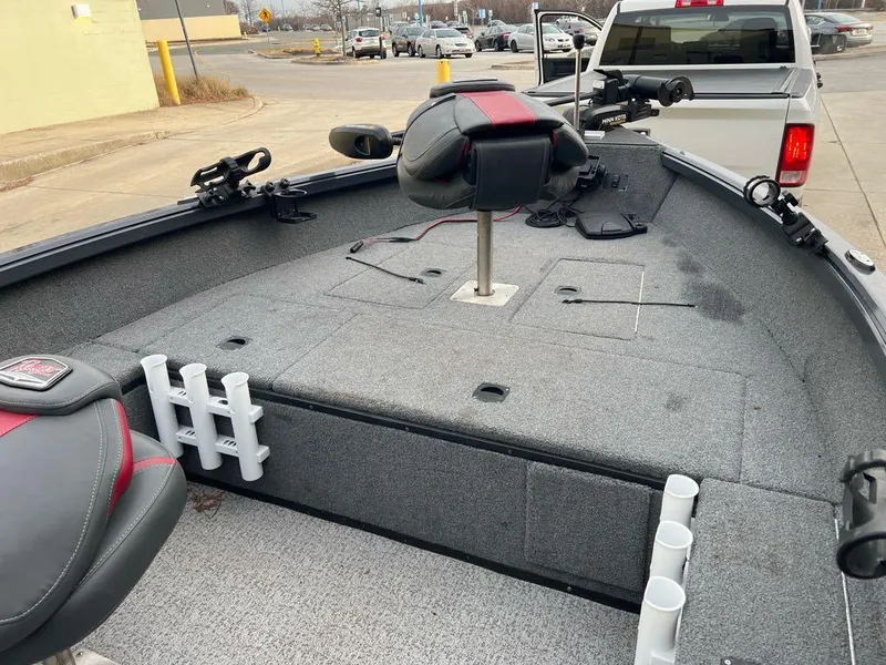 Slide: The Image of 2022 Ranger VS1665T boat interior with seating and rod holders in a parking lot. - 5