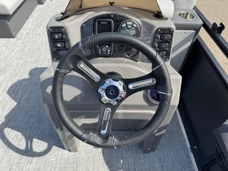 Slide: The Image of Steering wheel and dashboard of 2025 Qwest E 20 Lanai boat, featuring modern controls. - 15