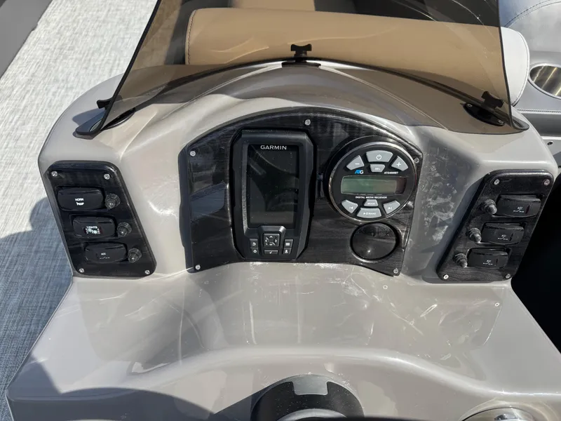 Slide: The Image of 2025 Qwest E 20 Lanai boat dashboard with Garmin navigation system and control panel. - 17