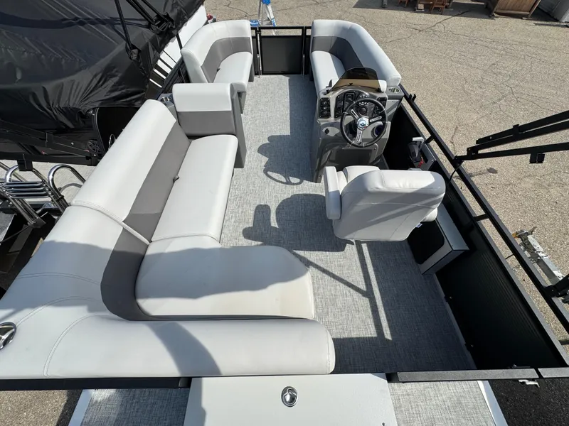 Slide: The Image of 2025 Qwest E 20 Lanai pontoon boat interior with plush seating and modern steering console. - 22