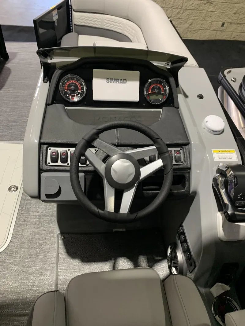 Slide: The Image of 2025 Godfrey Monaco 235 SD boat dashboard with steering wheel and control panel. - 4