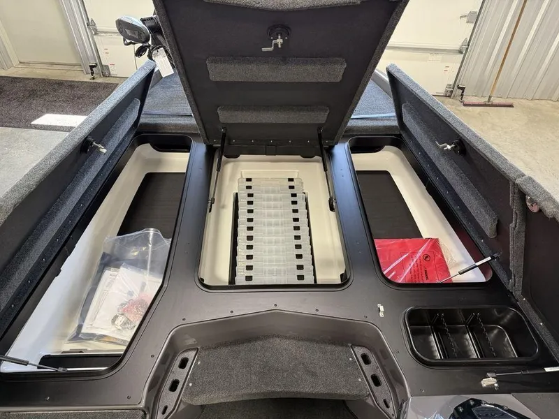 Slide: The Image of 2025 Skeeter ZXR20 boat storage compartments with open lids, showcasing organized interior space. - 15