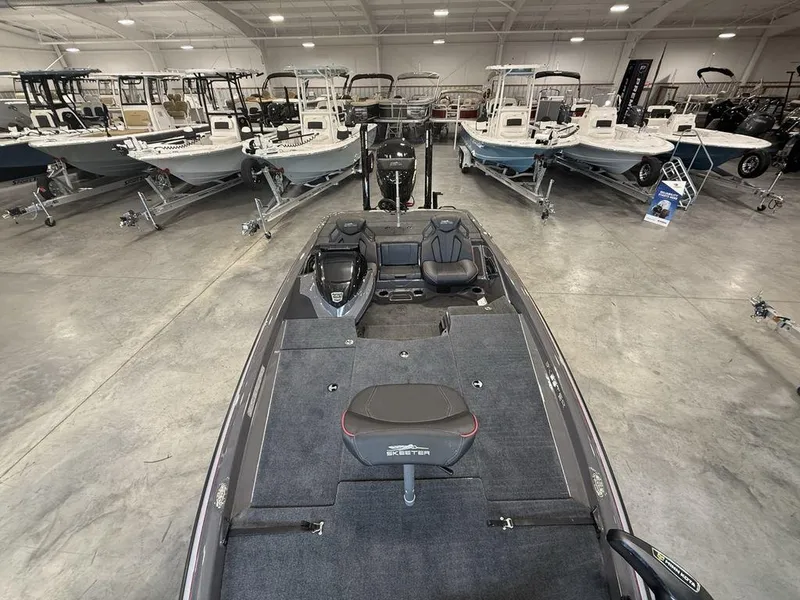 Slide: The Image of 2025 Skeeter ZXR20 boat in showroom, surrounded by various other boats. - 16