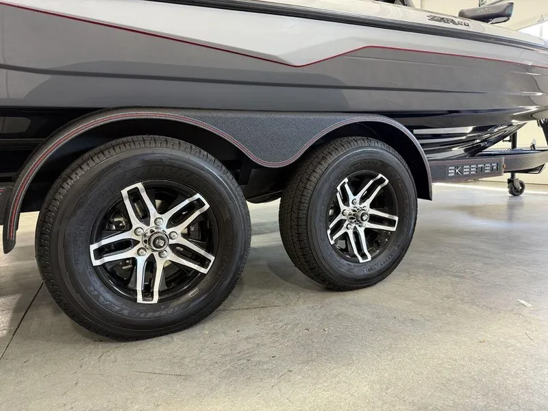 Slide: The Image of 2025 Skeeter ZXR20 boat trailer with dual wheels, sleek design, and metallic finish. - 4