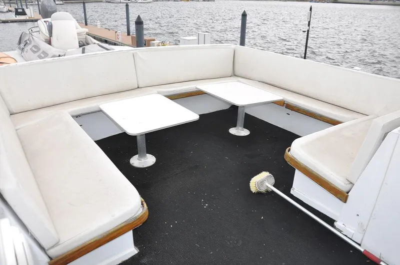 Slide: The Image of 1985 Hatteras 72 Motor Yacht deck with white seating and tables, overlooking water. - 10