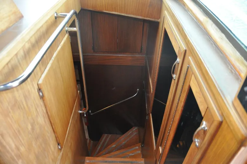 Slide: The Image of Wooden staircase inside 1985 Hatteras 72 Motor Yacht, featuring polished handrails and cabinetry. - 16
