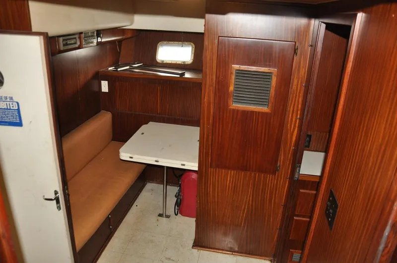 Slide: The Image of 1985 Hatteras 72 Motor Yacht interior with wood paneling and compact dining area. - 17