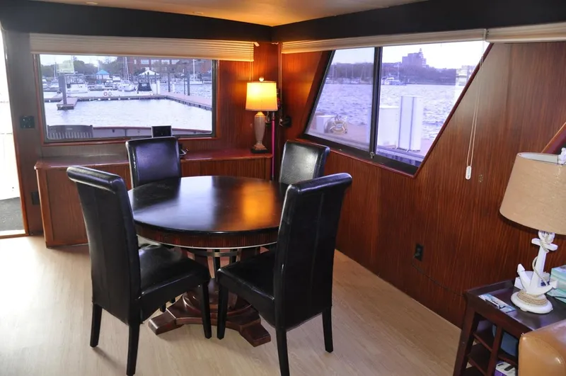Slide: The Image of Interior of 1985 Hatteras 72 Motor Yacht with dining area and waterfront view. - 29