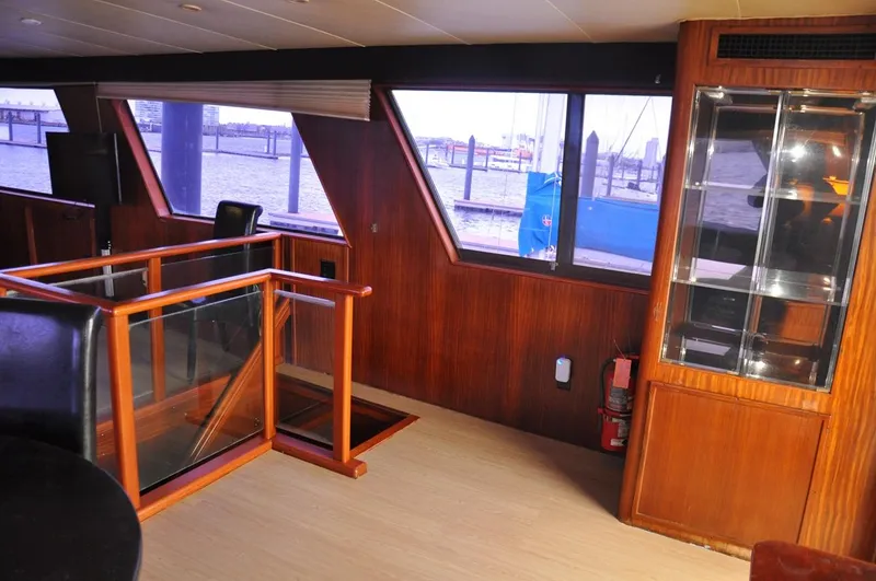 Slide: The Image of Interior of 1985 Hatteras 72 Motor Yacht with wood paneling and large windows. - 30