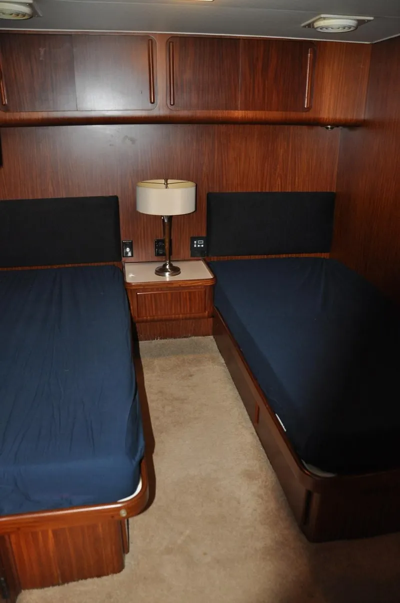 Slide: The Image of 1985 Hatteras 72 Motor Yacht cabin with twin beds and wooden interior. - 35