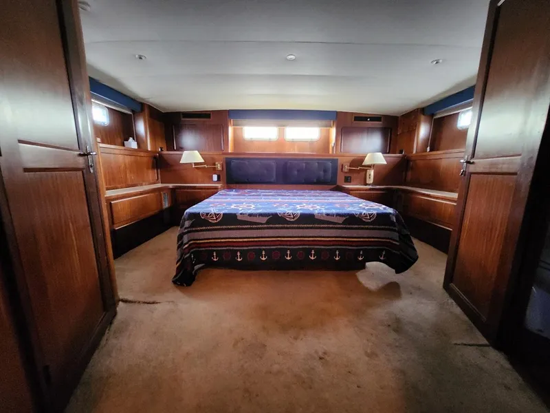 Slide: The Image of Luxurious bedroom interior of 1985 Hatteras 72 Motor Yacht with nautical-themed bedding. - 38
