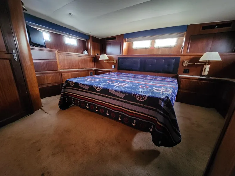 Slide: The Image of Luxurious bedroom interior of 1985 Hatteras 72 Motor Yacht with nautical-themed bedding. - 39