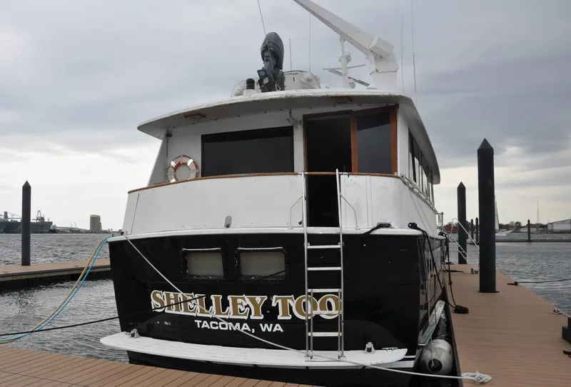 Slide: The Image of 1985 Hatteras 72 Motor Yacht docked, rear view, overcast sky. - 4