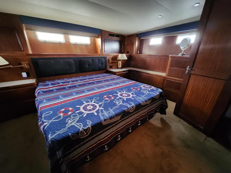Slide: The Image of Luxurious bedroom in 1985 Hatteras 72 Motor Yacht with nautical-themed bedding. - 40