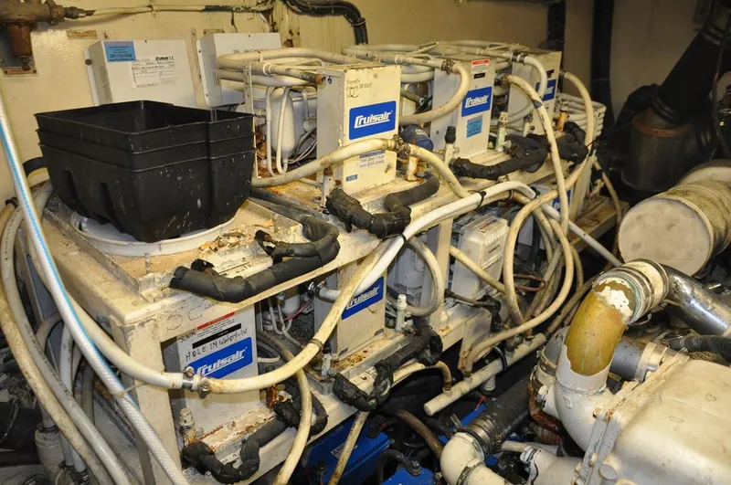 Slide: The Image of Engine room of 1985 Hatteras 72 Motor Yacht with multiple mechanical components and wiring. - 46