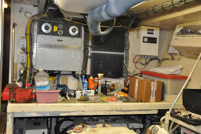 Slide: The Image of Engine room of 1985 Hatteras 72 Motor Yacht with control panels and maintenance tools. - 49