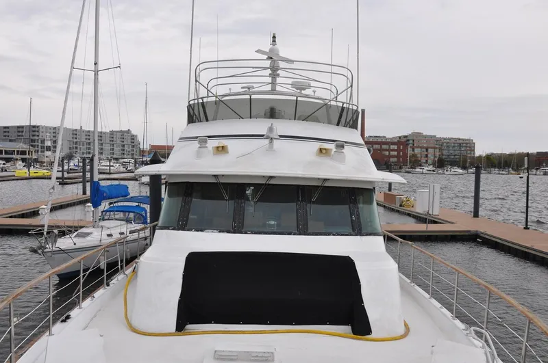 Slide: The Image of 1985 Hatteras 72 Motor Yacht docked at a marina, showcasing its sleek design and spacious deck. - 8