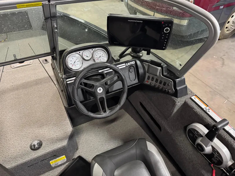 Slide: The Image of 2019 Lund 1675 Adventure Sport boat cockpit with steering wheel and control panel. - 13