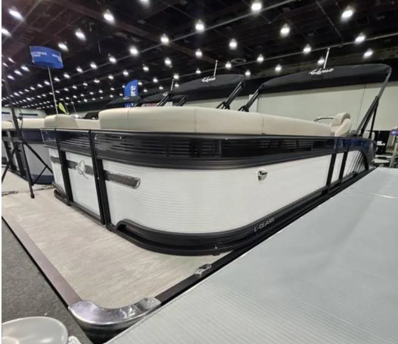 Slide: The Image of 2025 Qwest L 22RLS pontoon boat displayed indoors with elegant seating and sleek design. - 2