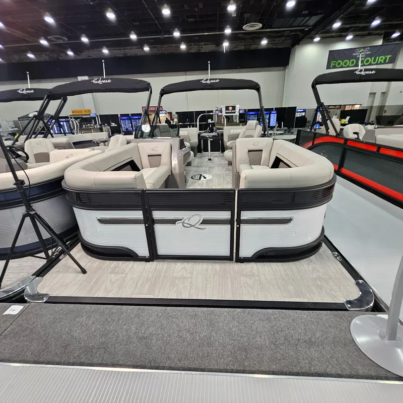 Slide: The Image of 2025 Qwest L 22RLS pontoon boat displayed indoors at a boat show. - 3