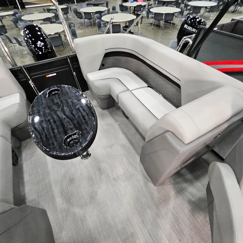 Slide: The Image of 2025 Qwest L 22RLS boat interior with gray seating and sleek black table. - 8