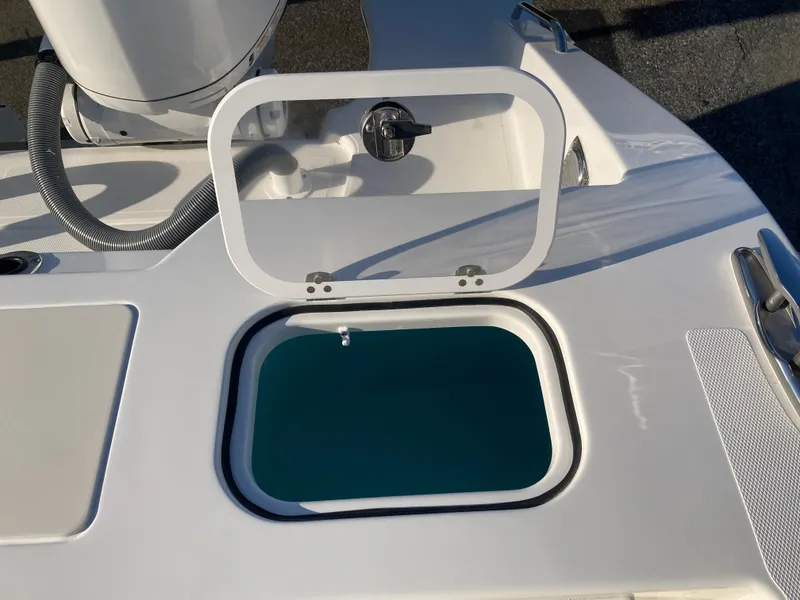 Slide: The Image of Open hatch on 2025 Pursuit OS 325 boat deck, revealing storage compartment. - 15