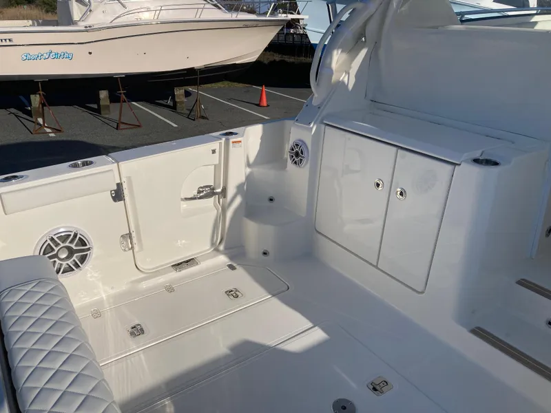 Slide: The Image of 2025 Pursuit OS 325 boat interior with white seating and storage compartments. - 17
