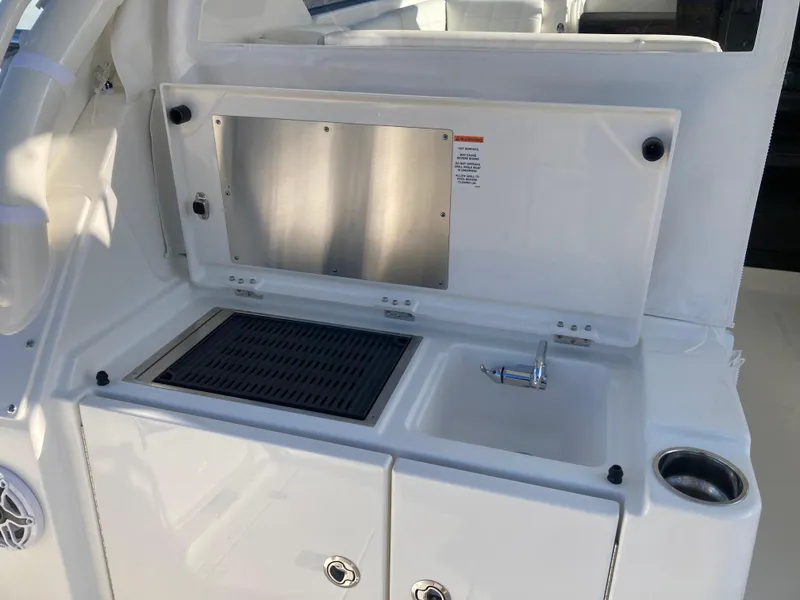 Slide: The Image of 2025 Pursuit OS 325 boat kitchenette with sink and grill. - 18