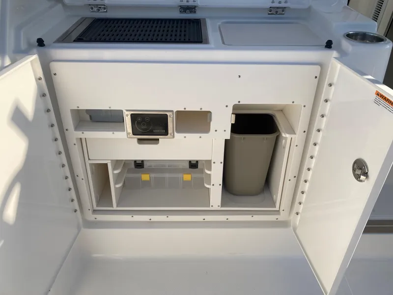 Slide: The Image of 2025 Pursuit OS 325 boat storage compartment with open doors, showcasing organized interior space. - 19
