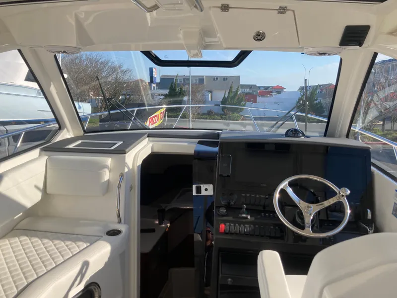 Slide: The Image of 2025 Pursuit OS 325 boat interior with modern helm, steering wheel, and navigation equipment. - 20