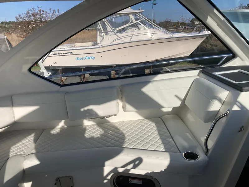 Slide: The Image of Interior of 2025 Pursuit OS 325 boat with white quilted seating and window view. - 24