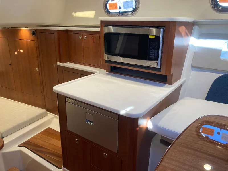 Slide: The Image of 2025 Pursuit OS 325 yacht interior with microwave and cabinetry. - 26