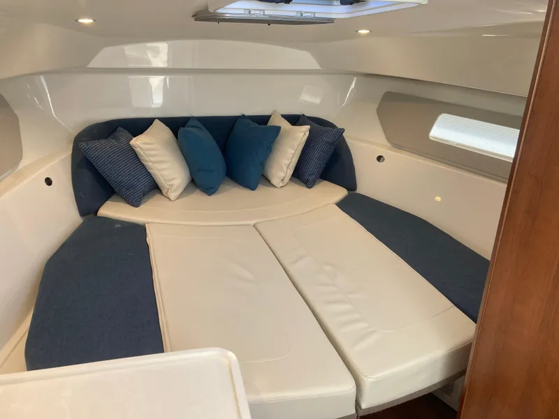 Slide: The Image of 2025 Pursuit OS 325 cabin interior with cozy seating and decorative pillows. - 28