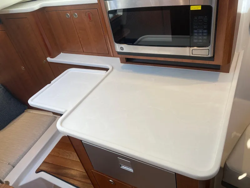 Slide: The Image of 2025 Pursuit OS 325 yacht interior with microwave and sleek countertop design. - 36