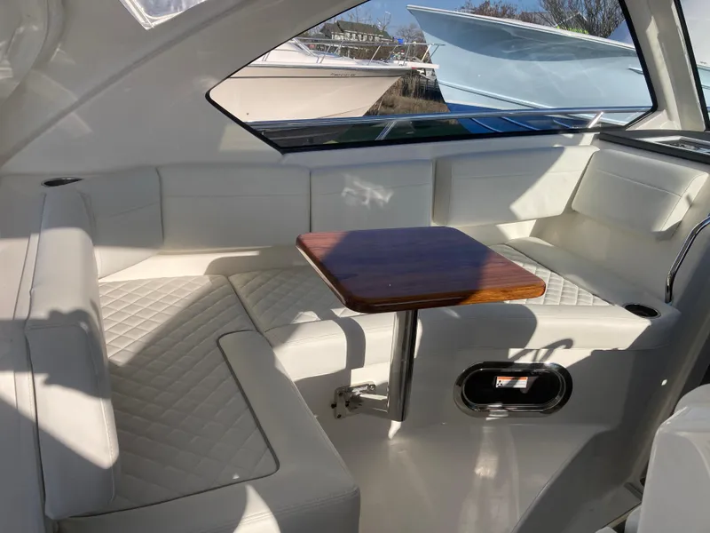 Slide: The Image of Interior of 2025 Pursuit OS 325 boat with white seating and wooden table. - 44